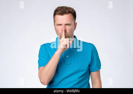 Schwere, gut aussehenden Mann hält Zeigefinger auf die Lippen, versucht, Verschwörung zu halten Stockfoto