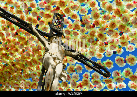 Jesus Christus am Kreuz unten hängenden Blumen, Frankreich Stockfoto