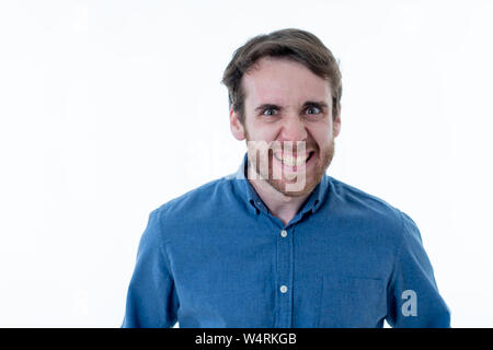 Nahaufnahme, Porträt der jungen bärtigen Mann in seinem 20s, lustige Gesichter an der Kamera Spaß haben. In Humor und Positive menschliche Mimik Stockfoto