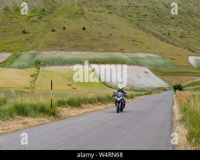 CASTELLUCCIO DI Norcia, Italien - Juli 14, 2019: Nicht Identifizierter Motorradfahrer auf offener Straße, Castelluccio Di Norcia, Italien. Stockfoto