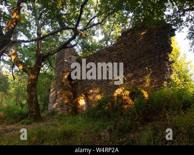 Kirche des Heiligen San Lorenzo in den Wäldern über Rapallo, Ligurien, Italien. Ruinen jetzt heißt es, die bis in das 12 Jahrhundert zurück. Beleuchtete durch Golden Sunset. Stockfoto