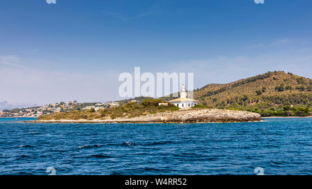 MALLORCA, SPANIEN - 5. Juli 2019: Die Insel Alcanada (in Spanisch: Illa d'Alcanada) und Leuchtturm sind am 5. Juli 2019 auf Mallorca, in Spanien gesehen. Stockfoto