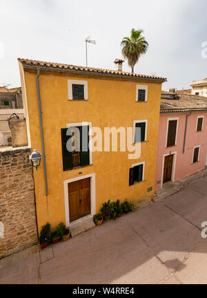 ALCUDIA, SPANIEN - Juli 7, 2019: Häuser und Gasse der Altstadt sind am 7. Juli 2019 in Alcudia, Spanien gesehen. Stockfoto