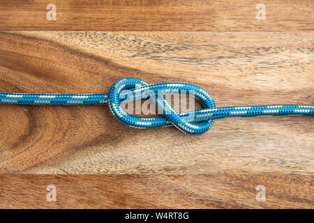 Abbildung 8 Knoten auf Holz- Hintergrund. Seil Knoten Stockfoto