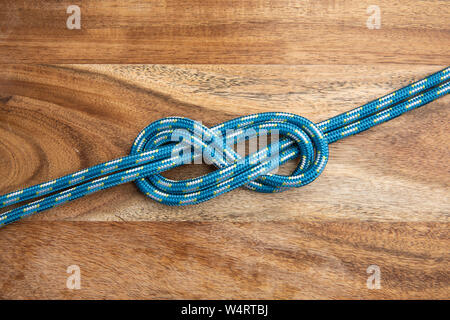 Doppelzimmer mit acht Knoten auf Holz- Hintergrund. Seil Knoten Stockfoto