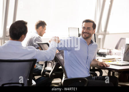 Die männlichen Kollegen Faust stoßen, am Arbeitsplatz, im Feiern teamwork Erfolg Stockfoto