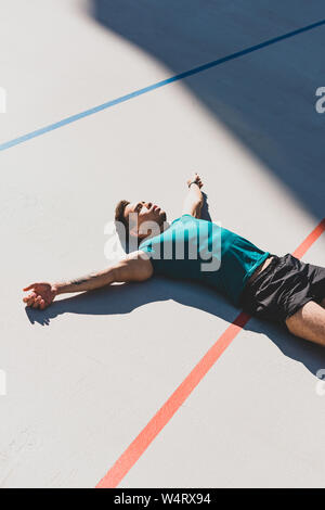 Mixed Race Sportler Festlegung auf der Laufstrecke und breitete die Arme Stockfoto