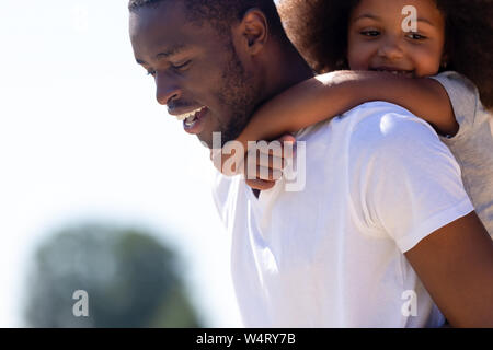 Nahaufnahme der afrikanischen Vater Tochter piggyback Ride Stockfoto