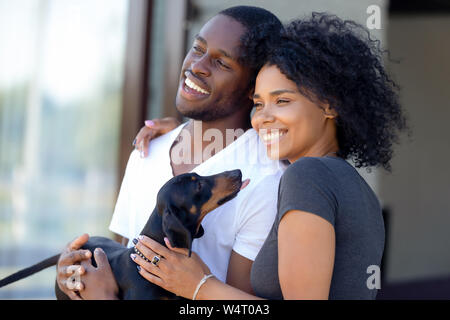 Gerne afrikanische tausendjährigen Paar stehen draußen halten Dackel Welpen Stockfoto