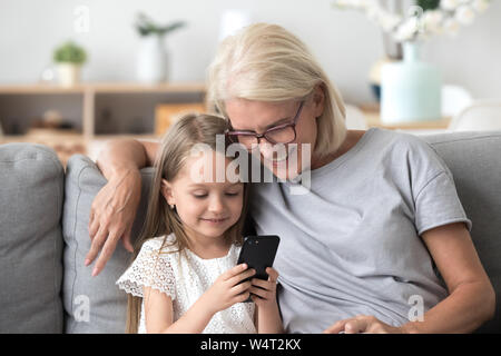 Oma und Enkel mit Phone sitzen auf der Couch Stockfoto