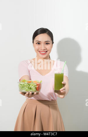 Frau mit grünen detox Smoothies, Salat in Glasschale auf weißem Hintergrund. Die richtige Ernährung, Vegetarische Kost, gesunden Lebensstil, Diät conc Stockfoto