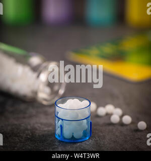 Moderne Farbe homöopathische Pillen in Kunststoffbehälter auf schwarzem Hintergrund, Frankreich Stockfoto