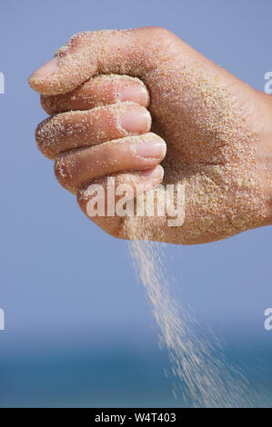 Sand durch die Hände laufen als Symbol für die laufende Zeit, verloren Stockfoto