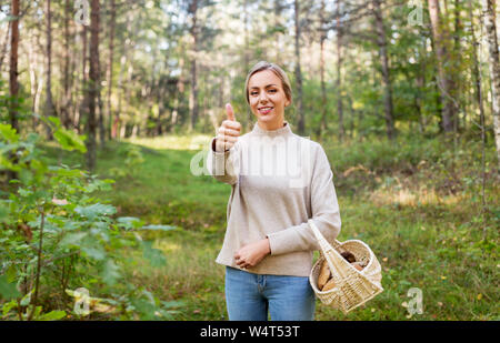 Frau mit Korb mit Pilzen im Wald Stockfoto