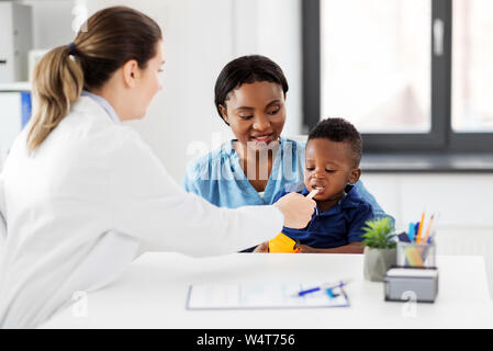 Arzt Prüfung der afrikanischen Babys Mund an der Klinik Stockfoto