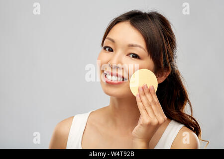 Asiatische Frau Reinigung Gesicht mit Peeling Schwamm Stockfoto
