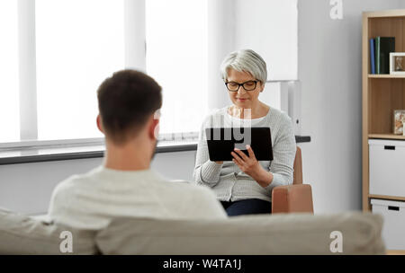 Leitender Psychologe mit Tablet Pcs und Patient Stockfoto