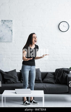 Unglückliche junge Frau Schreiend und gestikulierend während einer Depression zu Hause leiden Stockfoto