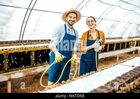 Porträt einer glückliche Arbeiter stehen im Gewächshaus auf einem Bauernhof für wachsende Schnecken. Konzept der Landwirtschaft Schnecken für Essen Stockfoto