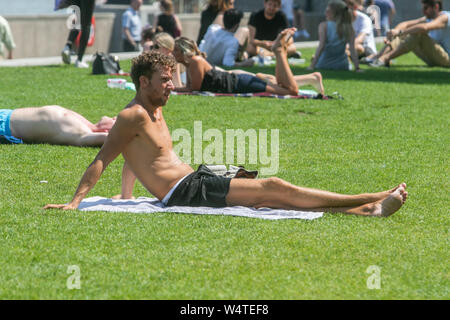 London, Großbritannien. 25. Juli 2019. Ein Mann sunbathes auf Londoner Riverside an einem heißen sweltering Tag in London, da Temperaturen werden erwartet, um Rekorde zu brechen.Credit: Amer ghazzal/Alamy leben Nachrichten Stockfoto