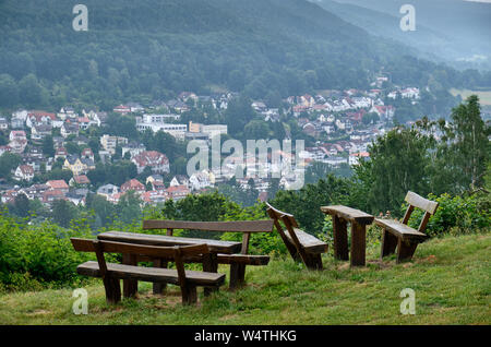 Ein Blick von der Mollkenberg Hill im Spessart auf das Stadtbild von Bad Orb mit leeren Bänken und Tischen im Vordergrund. Stockfoto