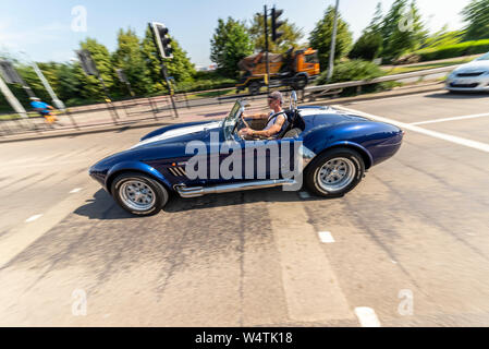 AC Cobra fährt an einem heißen, sonnigen Sommertag mit dem Top-down auf der A127 Southend on Sea, Essex, Großbritannien. Genießen Sie die Fahrt mit offenem Dach Stockfoto