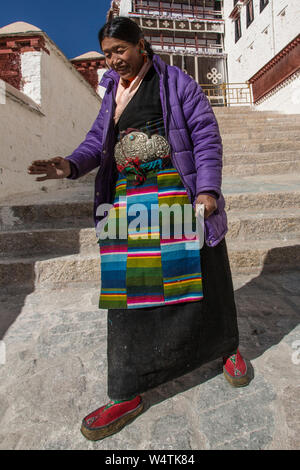 China, Tibet, Lhasa, zwei Khamba tibetische Frauen aus der Region Kham im Osten von Tibet auf einer Wallfahrt heiligen Stätten sie ihre farbenfrohen traditionellen bangdian oder pangden Schürzen tragen zu besuchen. Stockfoto