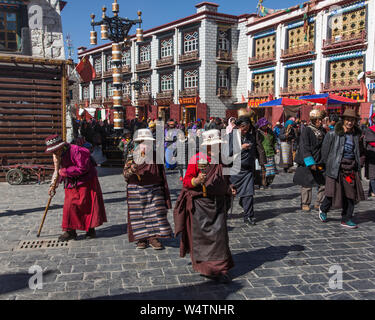 China, Tibet, Lhasa, Ältere tibetische Frauen in traditioneller Kleidung umrunden den Jokhang Tempel mit ihrem Beten Räder. Stockfoto