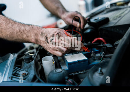 7/8-Ansicht automechaniker mit Schlamm auf den Händen zur Festsetzung Automobil Auto Repair Station Stockfoto