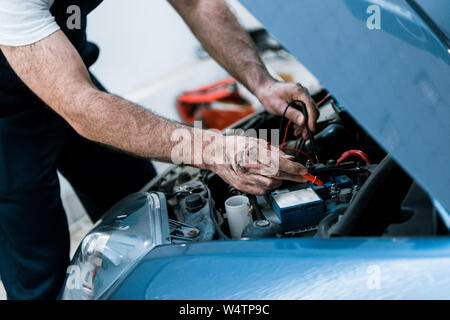 7/8-Ansicht automechaniker mit Schlamm auf den Händen zur Festsetzung Automobil Auto Repair Station Stockfoto