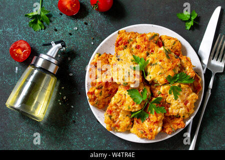 Hähnchen Schnitzel aus Hackfleisch, mit Paprika, Tomaten und grünen in einer Schüssel auf einem dunklen Stein Tabelle. Ansicht von oben flach. Stockfoto