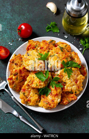 Hähnchen Schnitzel aus Hackfleisch, mit Paprika, Tomaten und grünen in einer Schüssel auf einem dunklen Stein Tabelle. Stockfoto