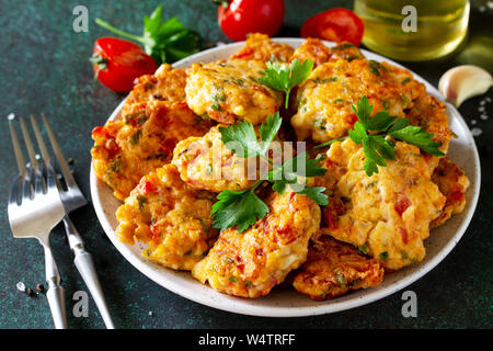 Hähnchen Schnitzel aus Hackfleisch, mit Paprika, Tomaten und grünen in einer Schüssel auf einem dunklen Stein Tabelle. Stockfoto