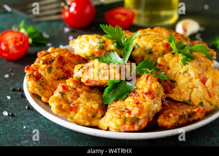 Hähnchen Schnitzel aus Hackfleisch close-up, mit Paprika, Tomaten und grünen in einer Schüssel auf einem dunklen Stein Tabelle. Stockfoto