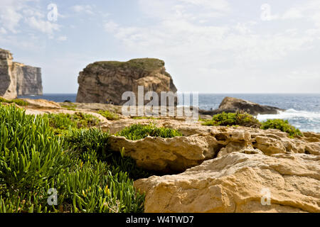 Malerischer Blick auf schöne grüne Vegetation und Klippen, Fungus Rock und das blaue Meer an der dweira Bay in Gozo, Malta. Stockfoto