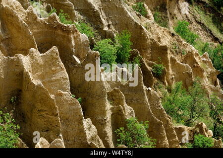 In der Nähe der berühmten Stob Pyramiden mit ungewöhnlichen Form gelbe und rote Felsformationen, grüne Büsche und Bäume um, West Anteil der Rila Gebirge Stockfoto