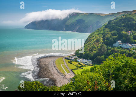 In der Ferne die Nebel rollt vom Vorland Punkt, wie die malerische Bucht von Lynmouth in Devon ist am frühen Morgen Sommer Sonnenschein. Stockfoto