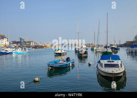 Boote auf einem ruhigen sonnigen Morgen im kleinen Fischerdorf Brixham, Devon, Großbritannien Stockfoto