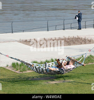 Warschau, Polen. Mai, 2019. Ein paar liegen auf einer Hängematte am Ufer der Weichsel Stockfoto