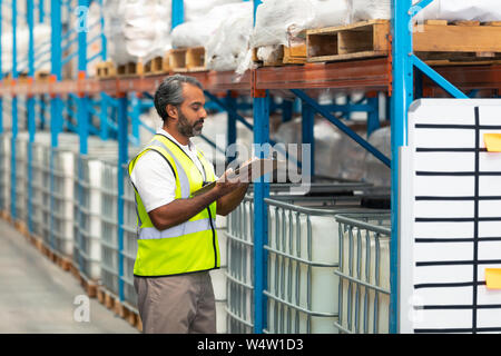 Männliche Arbeiter Bestände im Lager prüfen Stockfoto