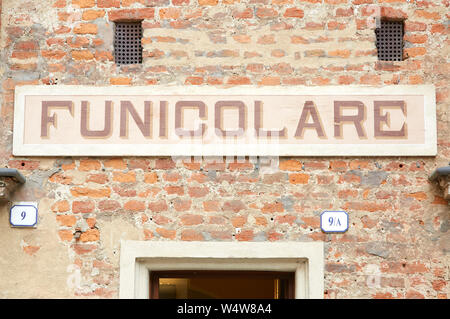 MONDOVI, Italien, 16. AUGUST 2016: Seilbahnstation Eingangsschild in roten Ziegeln Wand an einem sonnigen Sommertag in Mondovi, Italien. Stockfoto