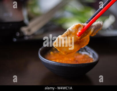 Stäbchen sind mit Schweinefleisch in Sichuan Pfeffer shabu eingeklemmt Stockfoto