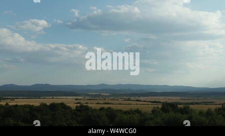 Fliegen aus dem Bereich über Wald und die Berge und Hügel. Stockfoto