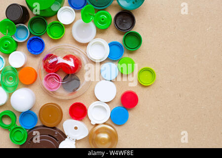 Bunte Flaschenverschlüsse aus Kunststoff und Kunststoff Glas Deckel auf Sperrholz Hintergrund. Stockfoto