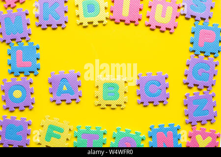 Alphabet Puzzle auf gelben Hintergrund. Ansicht von oben Stockfoto
