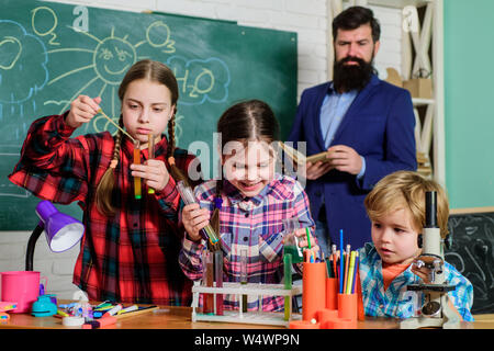 Die Fokussierung auf die Arbeit. Experimente mit Flüssigkeiten im Chemielabor. Kindern, die wissenschaftliche Experimente. Bildung. zurück zu Schule. Chemielabor. glückliche Kinder Lehrer. Stockfoto