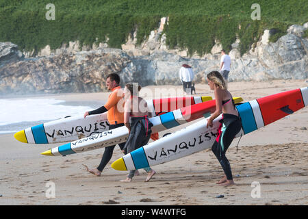 Mitglieder von Newquay Surf Life Saving Club Durchführung Vanquish Lebensrettende Race Boards starten eine Schulung bei Fistral in Newquay in Cornwall. Stockfoto