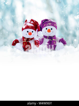 Zwei kleine Schneemänner das Mädchen und der Junge in Mützen und Schals auf Schnee im Winter. Festliche Hintergrund mit einem lustigen Schneemann. Weihnachtskarte, kopieren. Stockfoto