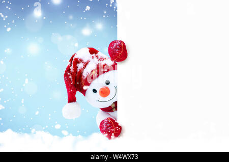 Wenig Schneemann in Mützen und Schals auf Schnee im Winter. Festliche Hintergrund mit einem lustigen Schneemann. Weihnachtskarte, kopieren. Stockfoto