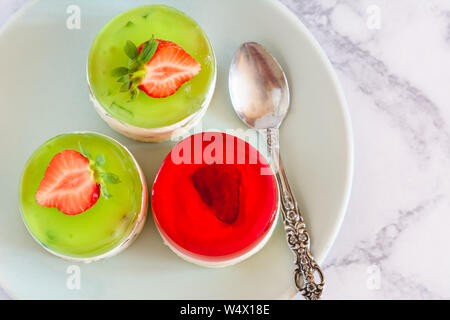 Mini runde kalt Käsekuchen mit Früchten Gelee und Erdbeeren. Stockfoto